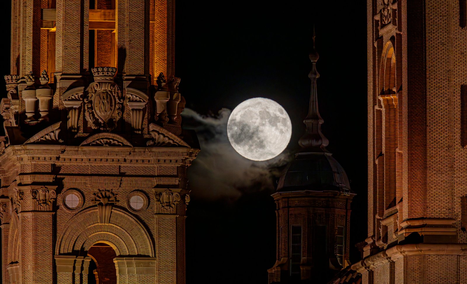 ZARAGOZA 21/07/2024.-Luna llena del mes de julio que asoma en Zaragoza entre las torres de la basílica de El Pilar. CIERZO VISUAL